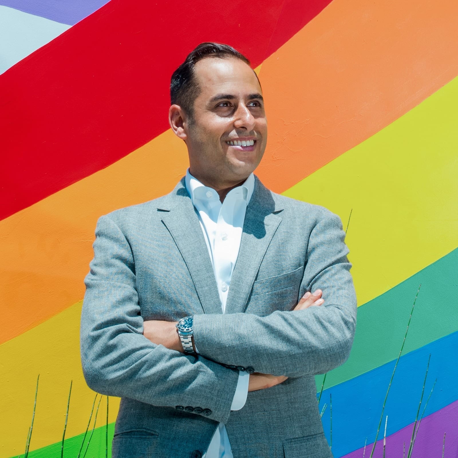Raymond Hekmat in front of a rainbow mural