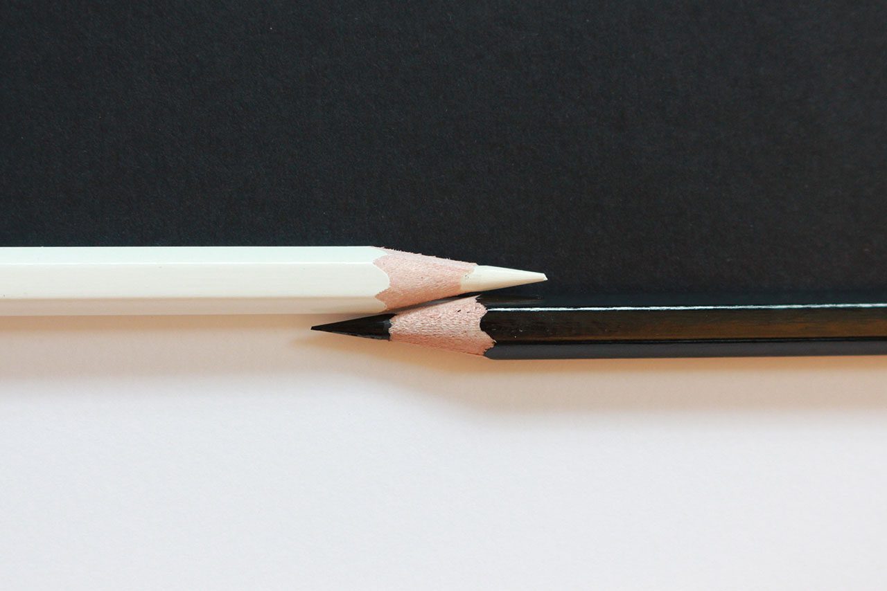 Black and white colored pencils representing two contrasting ideas